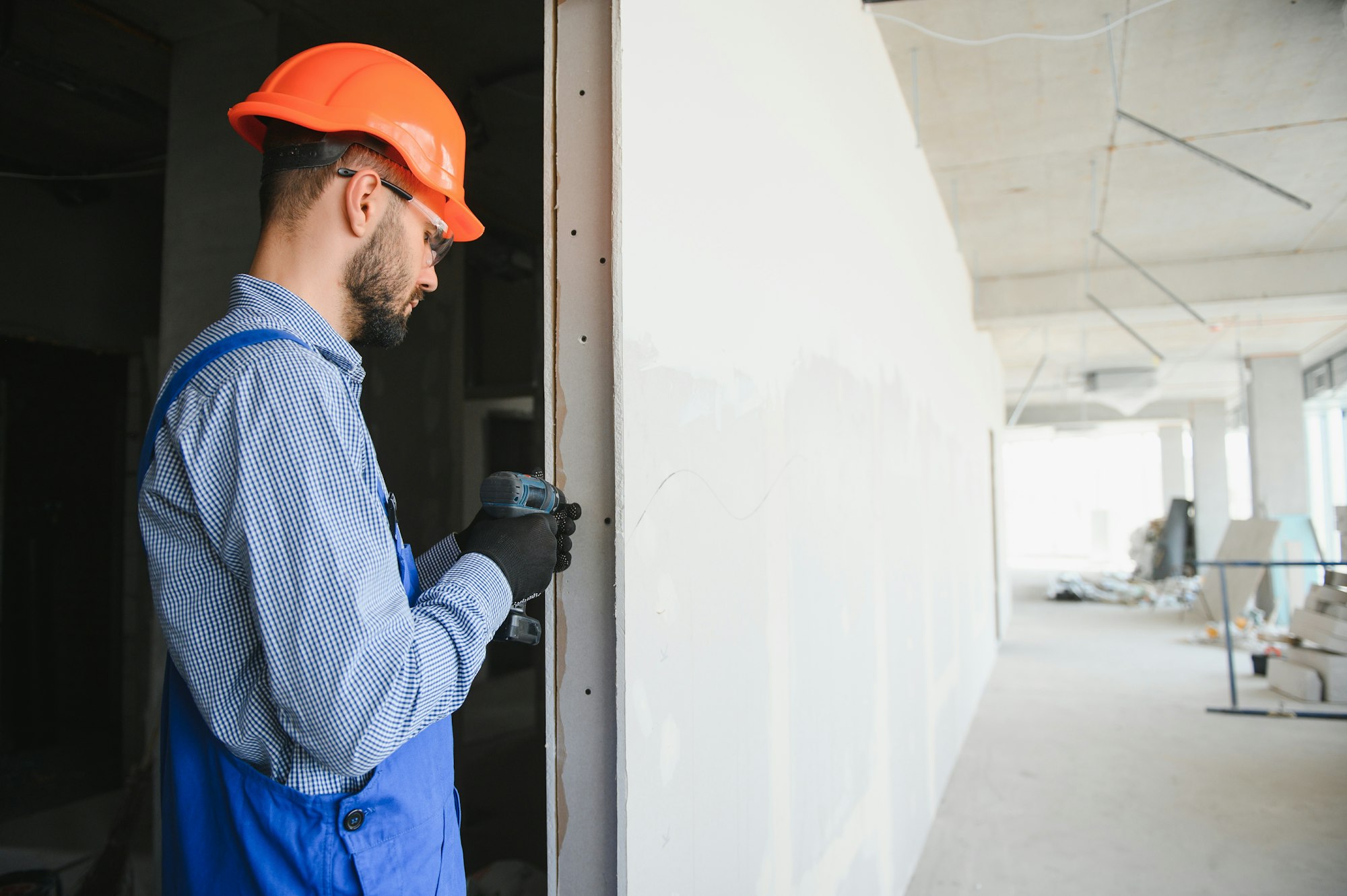 man drywall worker installing plasterboard sheet to wall