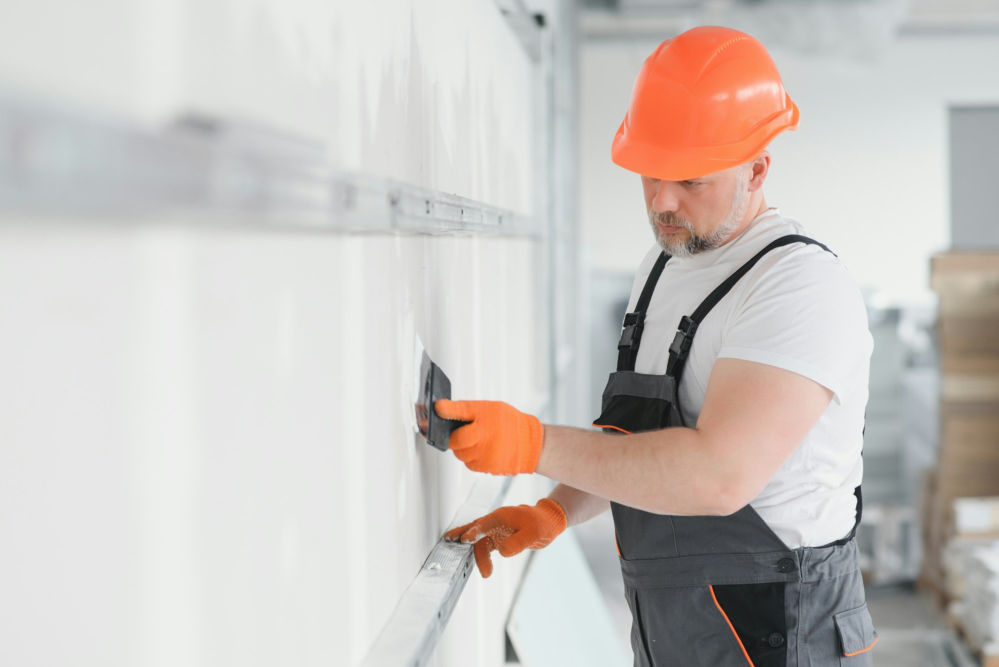 man drywall worker or plasterer putting mesh tape for plasterboard on a wall